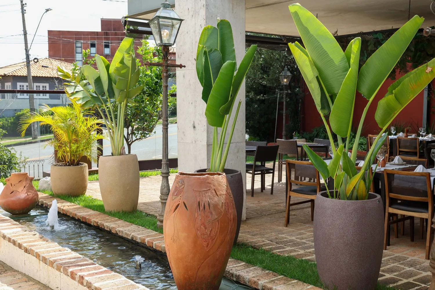 Jardim com vasos de barro e espelho d'água na entrada do Deck