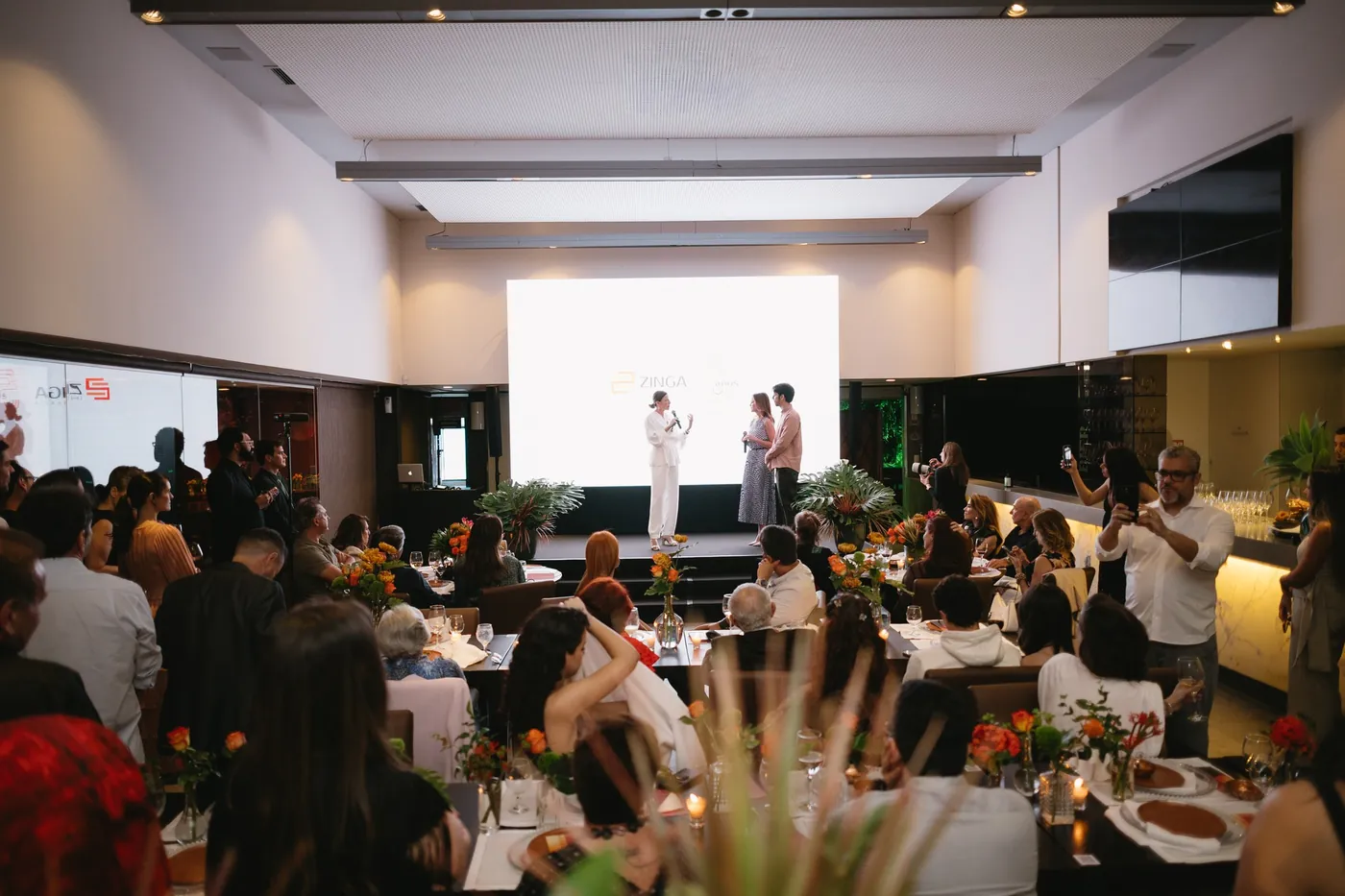 Evento social no Salão Principal do Pátria, com convidados e palco ao fundo